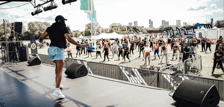 Faye leading a huge outdoor crowd from the stage at Hackney Moves