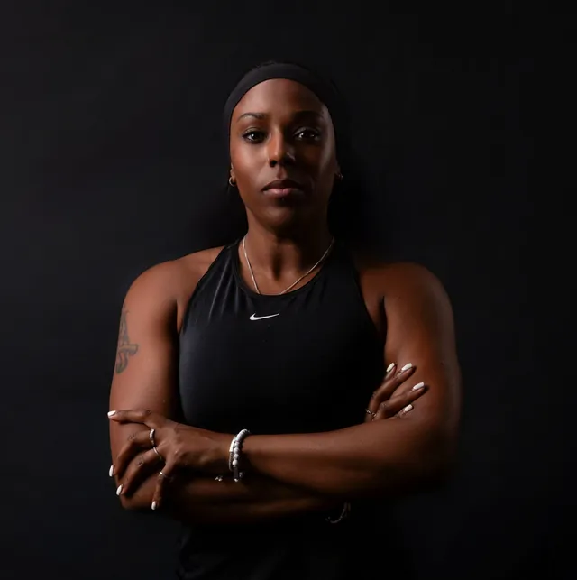 Faye Edwards in a black training top, arms folded, looking straight at the camera
