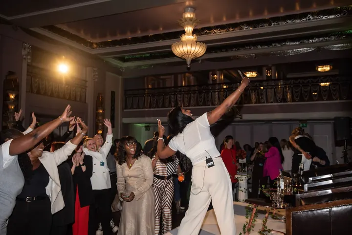 Faye on stage at Ladies Who Launch, the whole room on its feet with hands in the air